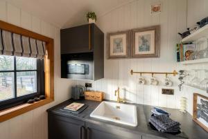 a kitchen counter with a sink and a window at Secluded Countryside Shepherd's Hut on Working Farm near Audley in Audley