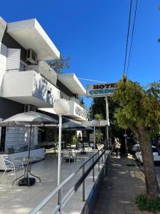 a restaurant with tables and umbrellas in front of a building at Nuevo Hotel Córdoba in Villa Carlos Paz