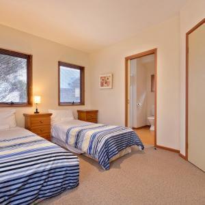 a bedroom with two beds and a bathroom at Square Bear in Dinner Plain