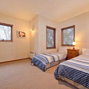 a bedroom with two beds and two windows at Square Bear in Dinner Plain