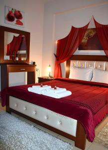 a bedroom with a large bed with a red bedspread at Relax pozar in Kato Loutraki