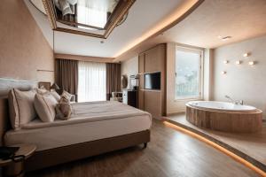 a bedroom with a large bed and a tub at Adalya Bliss in Side +138 photos