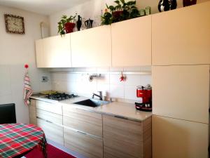 a kitchen with white cabinets and a sink at Casa Cesano mare in Senigallia