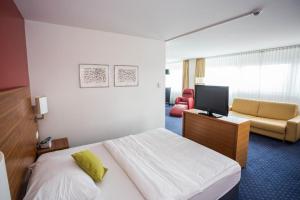 a hotel room with a bed and a television at Hotel Höri Inn in Höri
