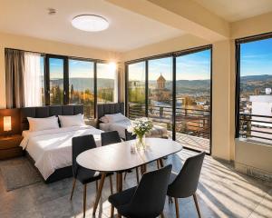 a bedroom with a bed and a table and chairs at Natali Apart-hotel in Tbilisi City