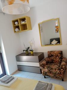 a living room with a chair and a mirror at Casa Cesano mare in Senigallia