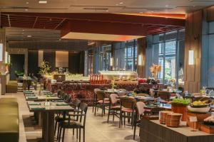 a dining room with tables and chairs in a restaurant at Nawana Sentul City by Alana in Bogor