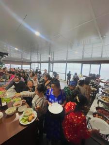 a group of people sitting at tables eating food at Sunrise Villa Hanoi in Hanoi