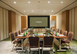 a conference room with a long table and chairs and a screen at Nawana Sentul City by Alana in Bogor +27 photos