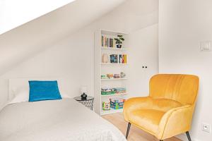 a bedroom with a bed and a chair at Cortaderia Haven - SPA - Basen, Jacuzzi, Sauna & Parking in Ustronie Morskie