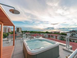 a hot tub on the balcony of a building at Aurea Attico con Jacuzzi e vista mare Lignano in Lignano Sabbiadoro