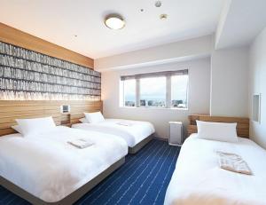 a hotel room with two beds and a window at Hearton Hotel Nishi Umeda in Osaka +60 photos