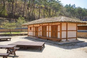 a small hut with a picnic table and benches at 청송 한옥호텔 안 in Imjŏn-dong