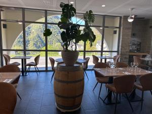 a restaurant with tables and a potted plant on a barrel at Auberge des isards in Aydius +71 photos
