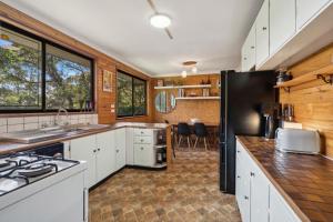 a kitchen with white cabinets and a black refrigerator at Lady Marmalade in Blackheath