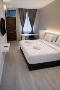 a hotel room with two beds and a television at EL Zahraa Moda Hotel Alor Setar in Alor Setar