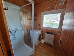 a small bathroom with a shower and a washing machine at Bungalow Tirolese in Molina di Ledro +40 photos
