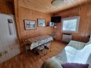 a dining room with a table and chairs in a room at Bungalow Tirolese in Molina di Ledro