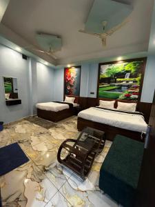 a room with two beds and a painting on the wall at Hotel 5G in Bhopal
