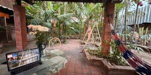 a glass table in a garden with a laptop on it at Villa Guesthouse Bangkok in Bangkok