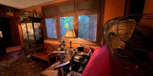 a room with a table and a lamp and a window at Villa Guesthouse Bangkok in Bangkok