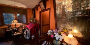 a room with a table with flowers and a window at Villa Guesthouse Bangkok in Bangkok