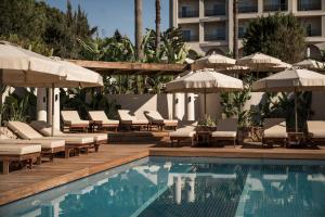 a pool with chairs and umbrellas next to a building at Adalya Bliss in Side