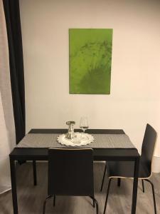 a black dining table with two chairs and a glass at Easy Stay Monteurswohnung in Geislingen an der Steige