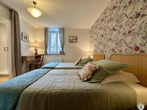 two beds in a bedroom with a floral wall at Le Bief in Pont-et-Massène +30 photos
