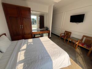 a bedroom with a bed and a desk and a television at Queen-Hotel in Quy Nhon