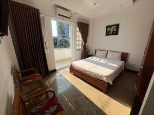 a bedroom with a bed and a large window at Queen-Hotel in Quy Nhon