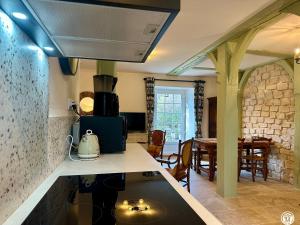 a kitchen with a stove and a dining room at Le Bief in Pont-et-Massène