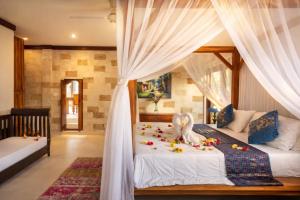 a bedroom with two beds with white curtains at Villa Kami Ubud in Ubud +13 photos