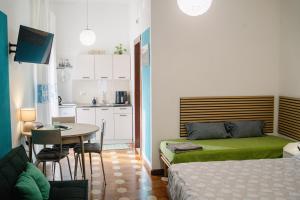 a bedroom with a bed and a table and a kitchen at ARCU DE CHELU - GUEST HOUSE in Modolo