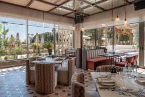 a restaurant with tables and chairs and large windows at Adalya Bliss in Side