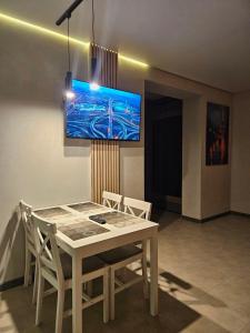 a dining room with a white table and chairs at Pysanka apartments in Kolomiya