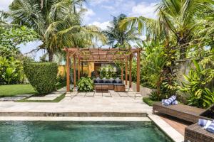 a backyard with a pool and a pergola at Villa Kami Ubud in Ubud
