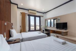 a hotel room with two beds and a desk at Lucky city hotel in Vientiane