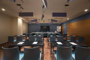 a conference room with tables and chairs and a screen at Hotel Castello in LʼAquila