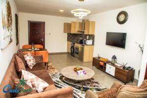 a living room with a couch and a tv at OASIS PARK RESIDENCE in East Legon