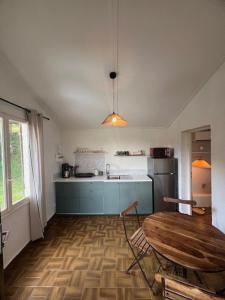 a kitchen with a wooden table and a kitchen with a refrigerator at maison 50m plage in Belvédère-Campomoro