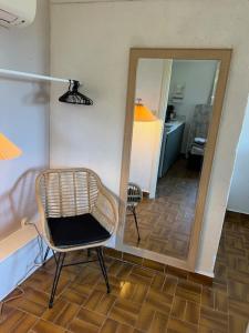 a chair sitting in a room with a mirror at maison 50m plage in Belvédère-Campomoro