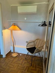 a room with a chair and a lamp and a floor at maison 50m plage in Belvédère-Campomoro