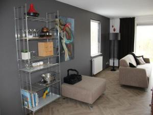 a living room with a room with a couch and a shelf at Appealing bungalow with garden in Breskens