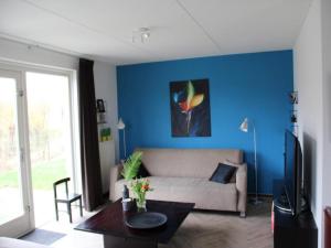 a living room with a couch and a table at Appealing bungalow with garden in Breskens