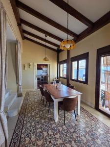 a dining room with a table and chairs on a rug at CasaManuelaMonesterio in Monesterio