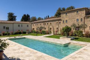 a swimming pool in front of a building at Borgo Ariano near Volterra by PosarelliVillas in Volterra