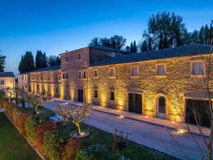 a large stone building with lights on it at Borgo Ariano near Volterra by PosarelliVillas in Volterra