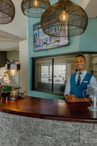 a man standing at a bar in a restaurant at Beach Hotel Swakopmund in Swakopmund +91 photos