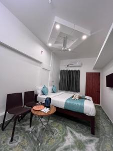 a bedroom with a bed and a table and chairs at THE CHALET- Pondicherry, Near Eden Beach - BMC in Pondicherry +86 photos
